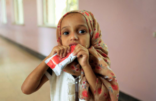 Young toddler eating a RUTF packet